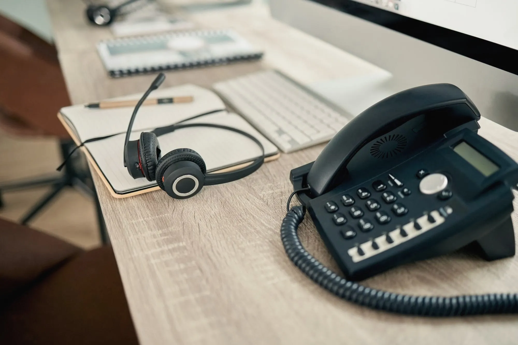 Bürotelefon und Headset auf einem Schreibtisch